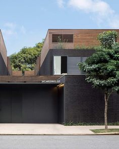 two black garages are on the side of a street with trees in front of them