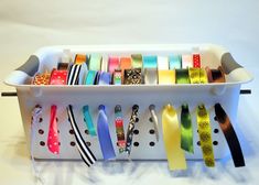 a white container filled with lots of different types of ribbons on top of each other