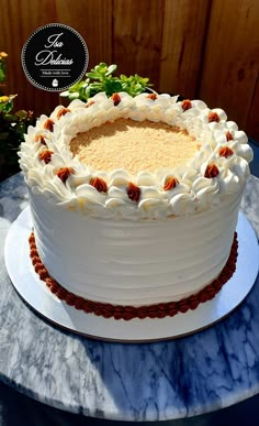 a large white cake sitting on top of a table next to a potted plant