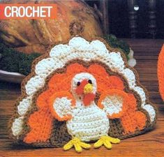 a crocheted turkey sitting on top of a wooden table