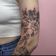 a woman's arm with flowers and leaves tattooed on the left side of her arm