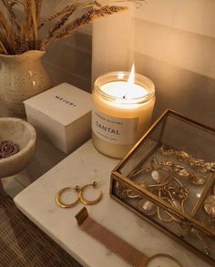 a candle and some jewelry on a table