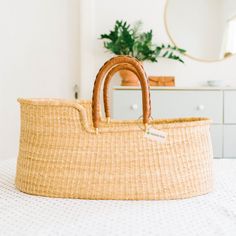 a wicker basket sitting on top of a bed next to a mirror and dresser