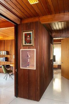 a room with wood paneling and pictures on the wall