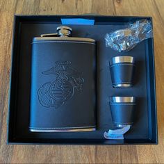 a leather flask and two shot glasses in a black box with the marine emblem on it