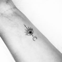 a black and white photo of a person's arm with an eye tattoo on it