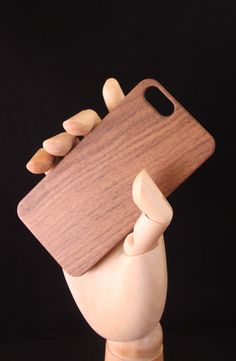 a wooden phone case is held up to show it's design