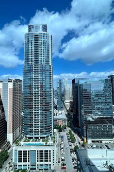 an aerial view of a city with tall buildings and cars parked in the street below