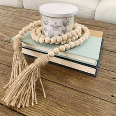 a wooden beaded bracelet with tassels on top of a stack of books