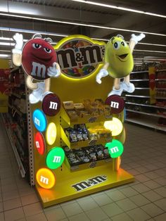 an m & m candy machine in a store with two characters on it's display