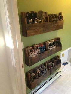 there are three wooden boxes with shoes in them on the wall next to each other