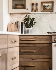 a kitchen with white cabinets and marble counter tops, including a stove top oven in the center