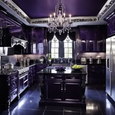 a large kitchen with purple cabinets and black counter tops, chandelier hanging from the ceiling