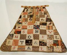 an old patchwork quilt is hanging on the wall