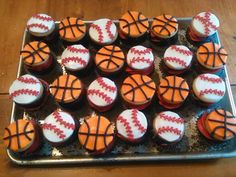 cupcakes decorated like basketballs and balls on a tray