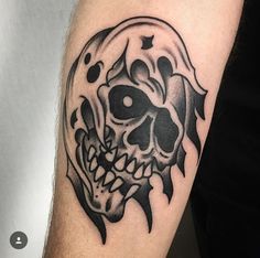 a black and white skull tattoo on the arm