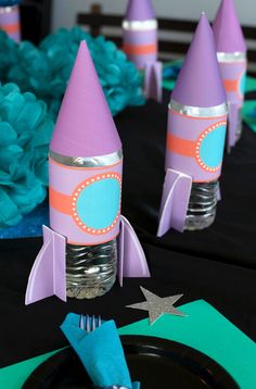 there are some party hats on top of each other in the shape of rocket ships