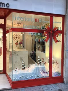 a red store front with christmas decorations in the window