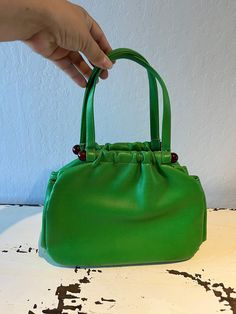 "Circa: 1950s 1960s Shamrock Green faux leather pouch handbag will be a sign of boldness. Beautiful rich green bag will hold more than you think with separate compartments. Tortoise lucite plastic bars and a simple snap closure, and that is very secure. Interior is black fabric.  DO YOU ACCEPT OFFERS? We do NOT accept offers or negotiate on pricing. We do offer layaways and have sales throughout the year. Shipping overages are always refunded. Label: Empress Fabric:  rayon interior, lucite plast 1960s Accessories, Faux Leather Pouch, Wedding Bags, Rich Green, Vintage Purses, Wedding Bag, Green Vintage, Soapy Water, Bags Purses