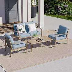 a blue couch and chair sitting on top of a rug in front of a house