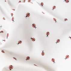 a white sheet with red and black ladybugs printed on it's side