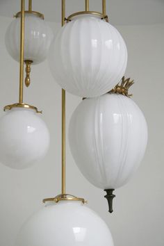 three white globe lights hanging from a ceiling