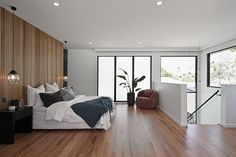 a bedroom with wood flooring and white walls