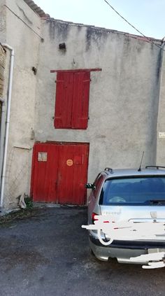 a car parked in front of a building with red doors