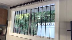 a kitchen window with bars on it and a pool in the back ground behind them