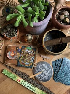 a table topped with potted plants next to cards and other items on top of it