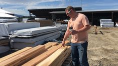 a man standing next to some wooden planks