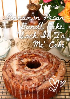 a bundt cake sitting on top of a cooling rack next to flowers and candles