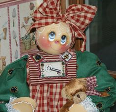 an old fashioned doll is sitting next to a teddy bear