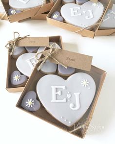 two heart shaped cookies in a box with the letters ej and j on them