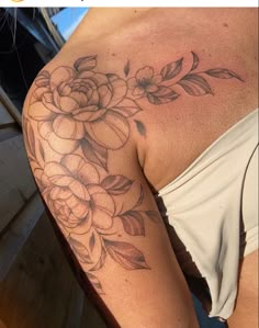 a woman's arm with flowers on it and the bottom half of her arm