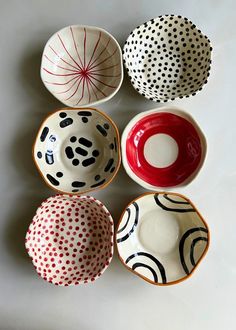 four bowls with different designs on them sitting next to each other