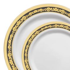 three white and gold dinner plates on a white background with an ornate design in the center