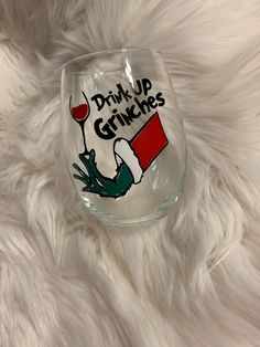 a wine glass with the words drink up grinnies on it