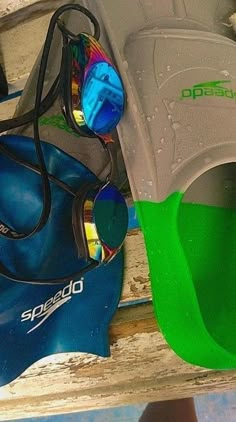 a pair of sunglasses sitting on top of a blue and green object next to other items