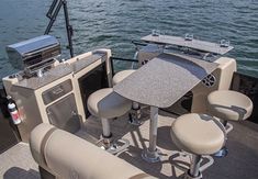 the inside of a motor boat with two seats and a table on the back deck