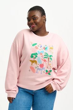 The crew neck Noah sweater has a semi-relaxed fit, ribbed collar and cuffs, and a super soft interior. The Tropical Safari design features a colourful jungle scene printed on soft peach base. Wunmi is is 5'7" and is wearing a size 18 Kate is 5'9" and is wearing a size 10 100% Organic Cotton Machine Washable (Delicate) Summer Crew Neck T-shirt With Tropical Print, Tropical Crew Neck T-shirt With Screen Print, Pink Crew Neck Tropical T-shirt, Pink Relaxed Fit Tropical T-shirt, Hawaiian Crew Neck Printed T-shirt, Safari Design, Jungle Scene, Rainbow Zebra, Yellow Sweatshirt