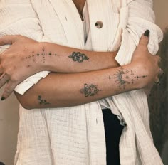 a woman's arm with tattoos on it, and her hand in the other