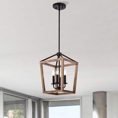 a light fixture hanging from the ceiling in a living room with windows and white walls