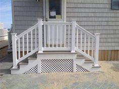 a white porch with pergolated steps and railings on the side of a house