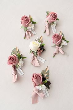 pink and white flowers are arranged on top of each other with name tags attached to them