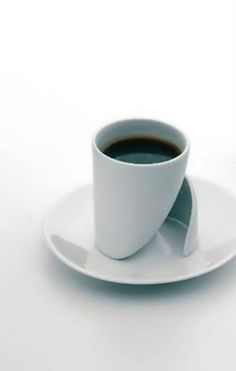 a cup of coffee sitting on top of a white saucer