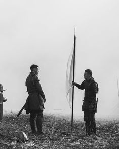 two men standing next to each other holding flags