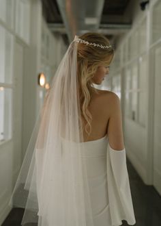 a woman in a white dress is wearing a veil