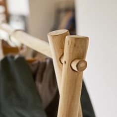 a close up of a wooden pole with clothes hanging on the wall in the background