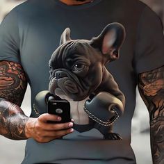 a man holding a cell phone while wearing a shirt with an image of a dog on it